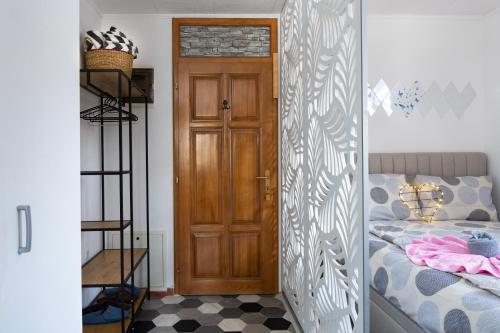 a bedroom with a door and a bed with a checkerboard floor at Apartman Bn Vlasic in Vlasic