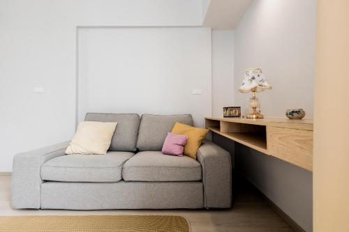 a living room with a gray couch with two pillows at SPACIOUS AND BRIGHT 2BR TownHouse7 MonkeyHill in Ban Sam Kong
