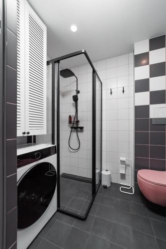 a bathroom with a shower and a pink toilet at Stilinga studija su visais patogumais in Šiauliai