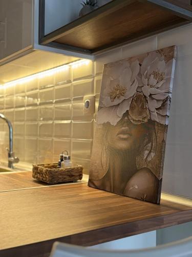 a painting of a woman on a kitchen counter at Comfortable Family Apartment P3 in Larisa