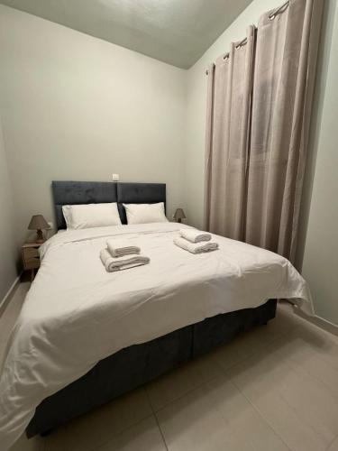 a bedroom with a large bed with two towels on it at Comfortable Family Apartment P3 in Larisa