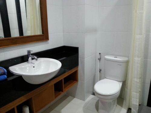 a bathroom with a white toilet and a sink at Nina Hotel Syariah in Salatiga