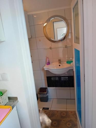 un piccolo bagno con lavandino e specchio di Ravne Apartman a Visoko