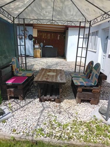 un patio con due sedie, un tavolo e una tenda di Ravne Apartman a Visoko