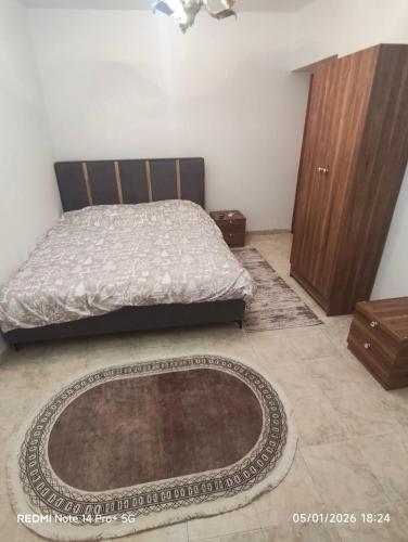 a bedroom with a bed and a rug on the floor at Oremari Home in Korçë
