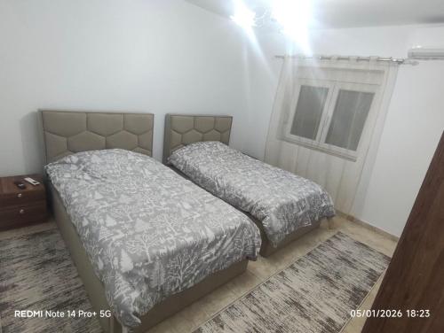 a bedroom with two beds and a window at Oremari Home in Korçë