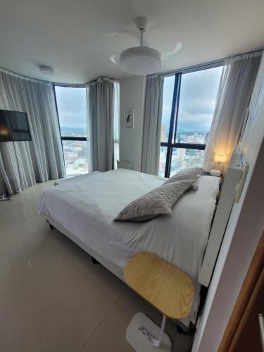 a bedroom with a large bed and a large window at Apartamento Ejecutivo Premium Riviera Tower in Villa Carlos Paz
