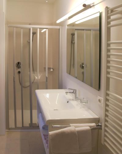 a white bathroom with a sink and a shower at Apartment Edelweiss in Brunico
