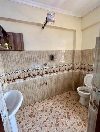 a bathroom with a toilet and a sink at Haven one bedroom in Busia