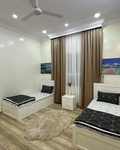 a bedroom with two beds and a rug at شالية مزايا الاشخرة in Al Sharqiyah