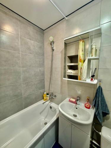 a bathroom with a sink and a bath tub and a sink at Two-room apartment in Astana