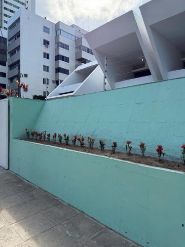 a blue fence with plants on the side of a building at CASAMAR Olinda in Olinda