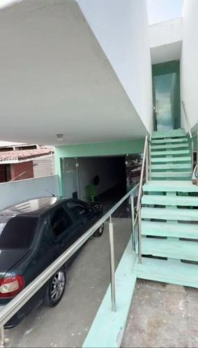 a car is parked in a garage with stairs at CASAMAR Olinda in Olinda