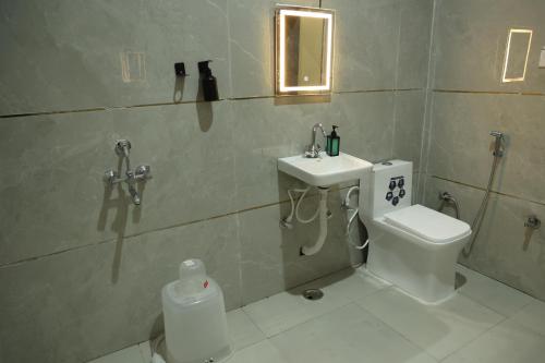 a bathroom with a toilet and a sink at Monkey River Resort Madla in Rājgarh