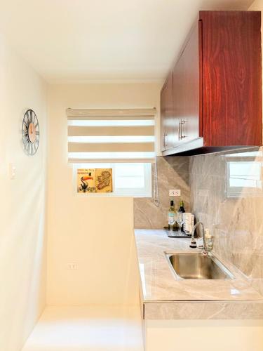 a kitchen with a sink and a window at The Tuscan Townhouse in Tarlac