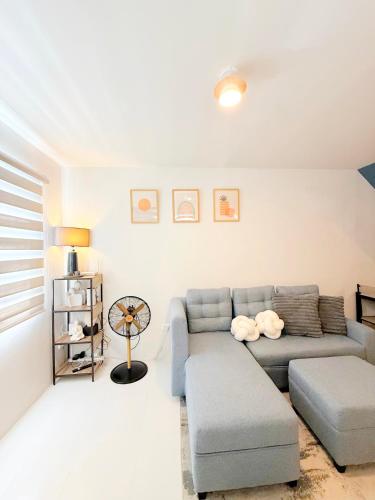 a living room with a blue couch and a table at The Tuscan Townhouse in Tarlac