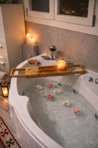 a bath tub with a glass of wine and candles at B&b GIOIA in Massa Lombarda