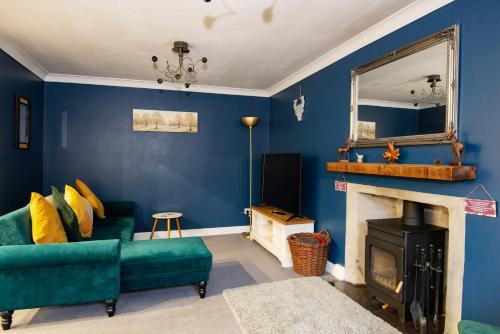 a living room with a green couch and a mirror at Charming 2 Bedroom Flat in the Heart of Kirriemuir in Kirriemuir