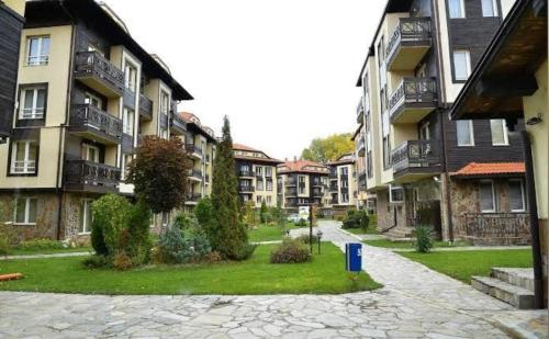 a cobblestone street in a city with apartment buildings at Apartment Danik City Garden in Bansko