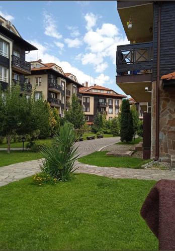a walkway in a park with apartment buildings at Apartment Danik City Garden in Bansko
