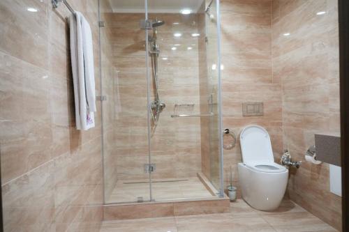a bathroom with a shower with a toilet in it at Hotel Arai Plaza in Taraz