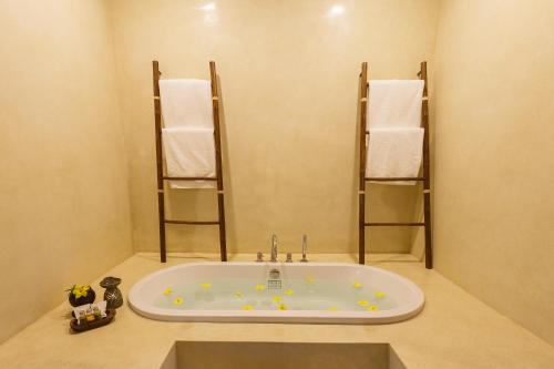 a bathroom with a bath tub with towel racks at Azalea Village in Chiang Dao
