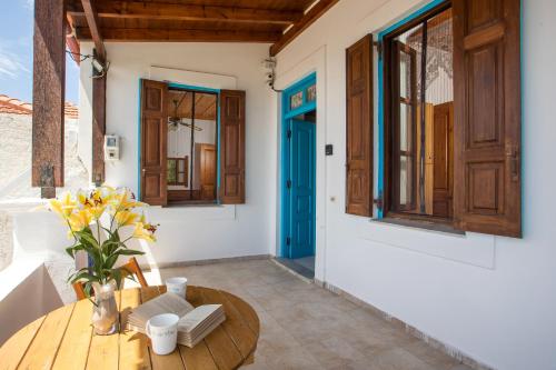 a room with a wooden table and a blue door at Isminis Villa in Halki