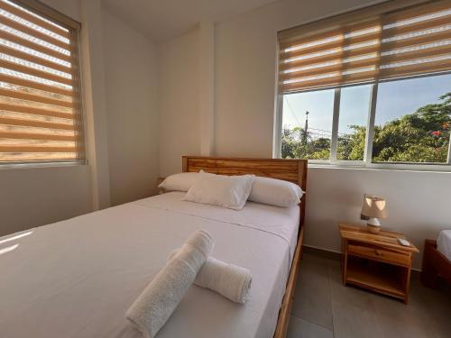 a bedroom with a bed with two towels on it at Almar in Olón