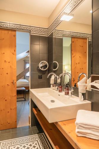 a bathroom with a sink and a mirror at The Alpina Mountain Resort in Tschiertschen