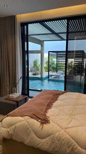 a bedroom with a large bed and a swimming pool at Areenachalet in Ibrā