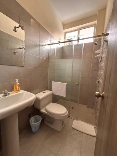 a bathroom with a toilet and a sink and a shower at Almar in Olón