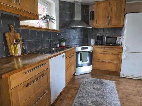 a kitchen with wooden cabinets and a white refrigerator at Apartment Norrgården in Genevad