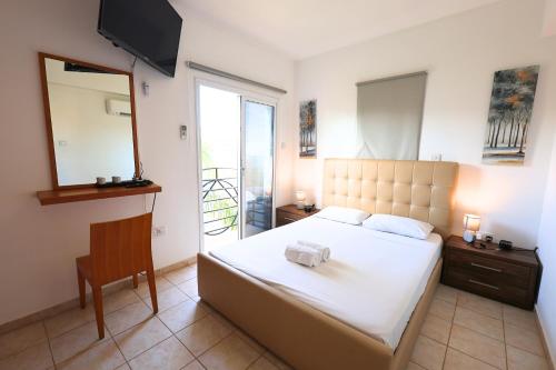 a bedroom with a bed and a mirror and a chair at GREAT VILLA MARIA in Paralimni