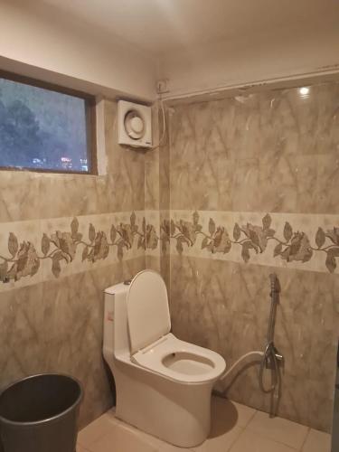 a bathroom with a toilet and a shower at Krishna Homestay in Bhowāli
