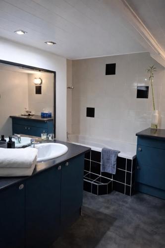 a bathroom with a sink and a large mirror at L'industriel - meublé de tourisme 4 étoiles in Fécamp