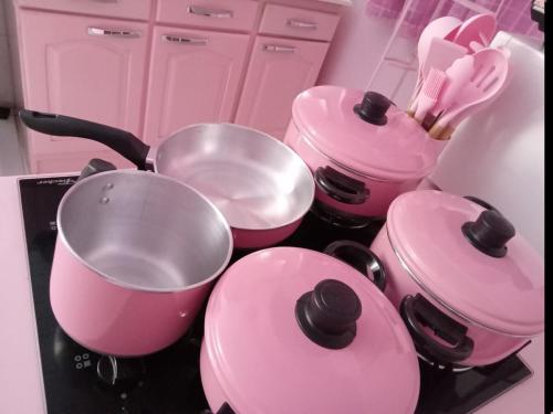 a kitchen with pink pots and pans on a stove at Casa Rosa in Frederico Westphalen