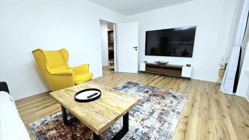 a living room with a table and a tv at Ioana Homes Ferienwohnung in Abstatt