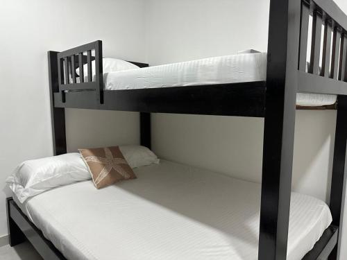 two bunk beds with white sheets and a pillow at Coral del mar in Tolú