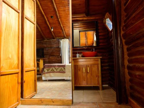 a bathroom with a mirror and a bed in a room at Aventurados in Potrerillos