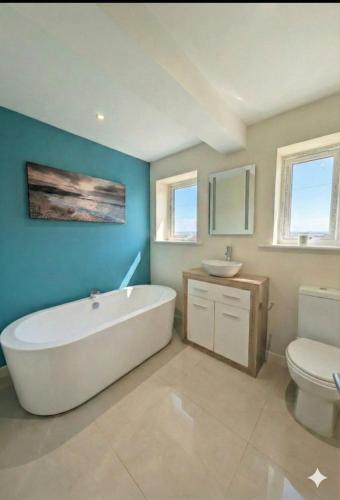 a bathroom with a tub and a sink and a toilet at Bournemouth Beach & Sea Views in Bournemouth