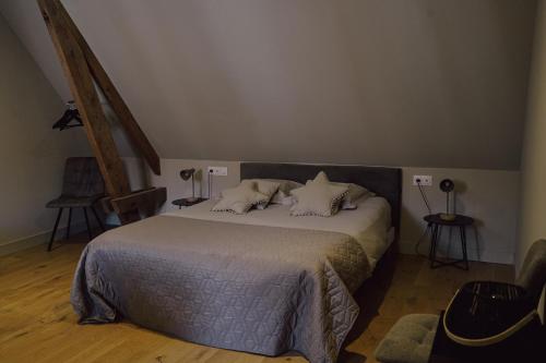 a bedroom with a large bed with pillows at Les Suites Gueguen in Chablis