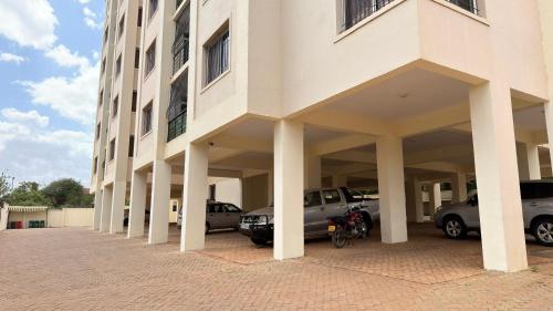 Hillsview Apartment في Voi: مبنى كبير مع سيارات متوقفة في موقف السيارات