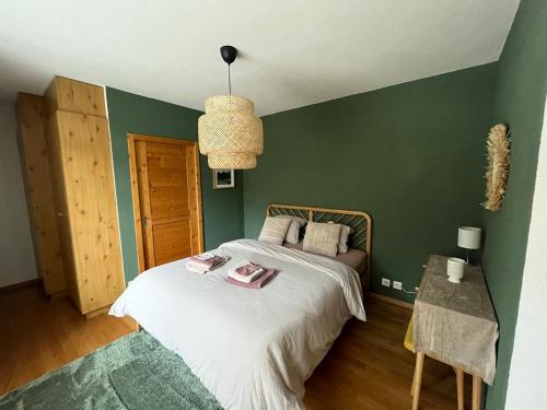 a bedroom with a bed and a green wall at Appartement 01 Résidence Le Grand Combin à Champex in Champex