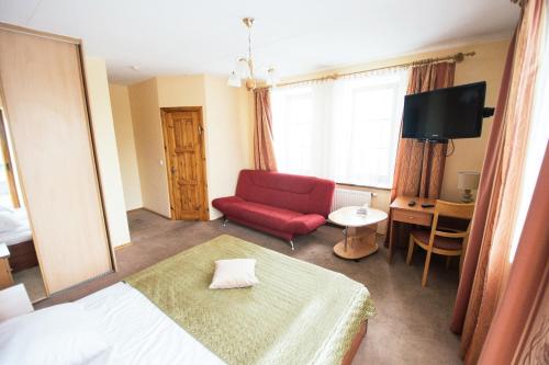 a bedroom with a red couch and a red chair at Svečių namai Lingės in Nemėžis