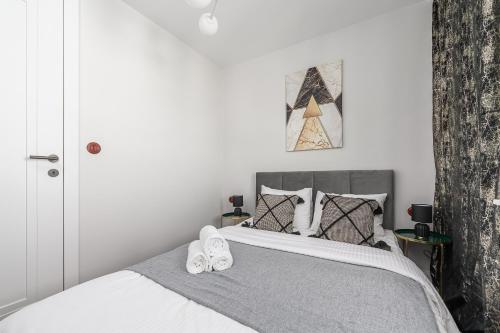 a bedroom with a bed with two slippers on it at Lumina I Premium 3BR Apartment with Balcony I City View in Warsaw