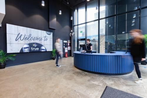 a lobby with people walking around a desk in a building at For Students Only Stylish Studios in Glasgow in Glasgow