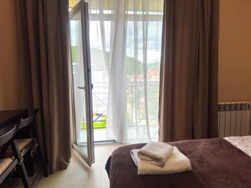 a bedroom with a bed and a large window at Glory Apart Polyana in Polyana