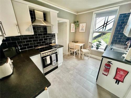 a kitchen with a sink and a stove top oven at Island View in Benllech