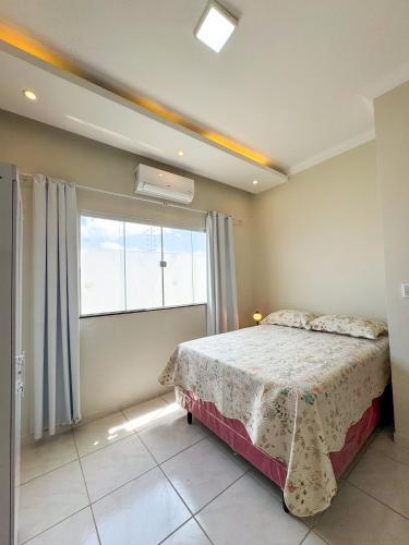 a bedroom with a bed and a large window at Casa Vitória-régia in Camocim