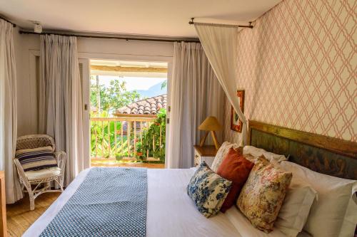 a bedroom with a bed and a sliding glass door at TW Guaimbê Exclusive Suítes in Ilhabela